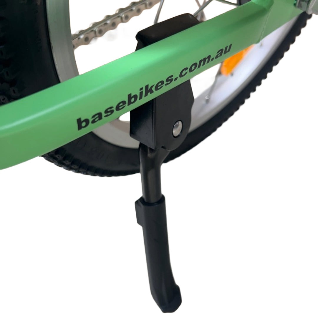 Close-up of a green bicycle with a chain-stay mounted kickstand attached.