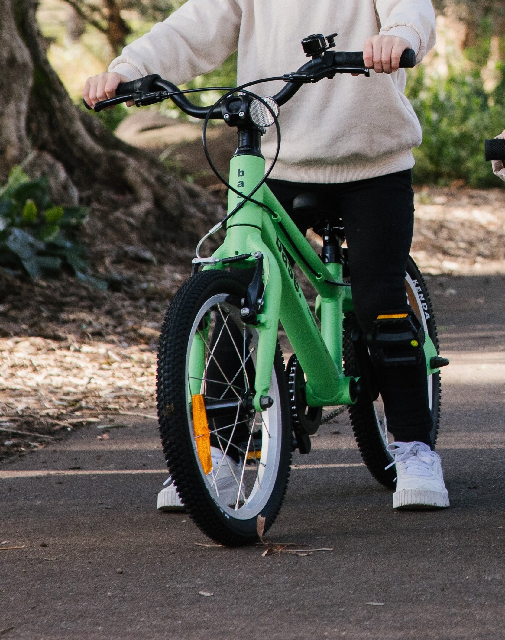Close up on the handlebars of bicycle in a natural setting with trees and plants.