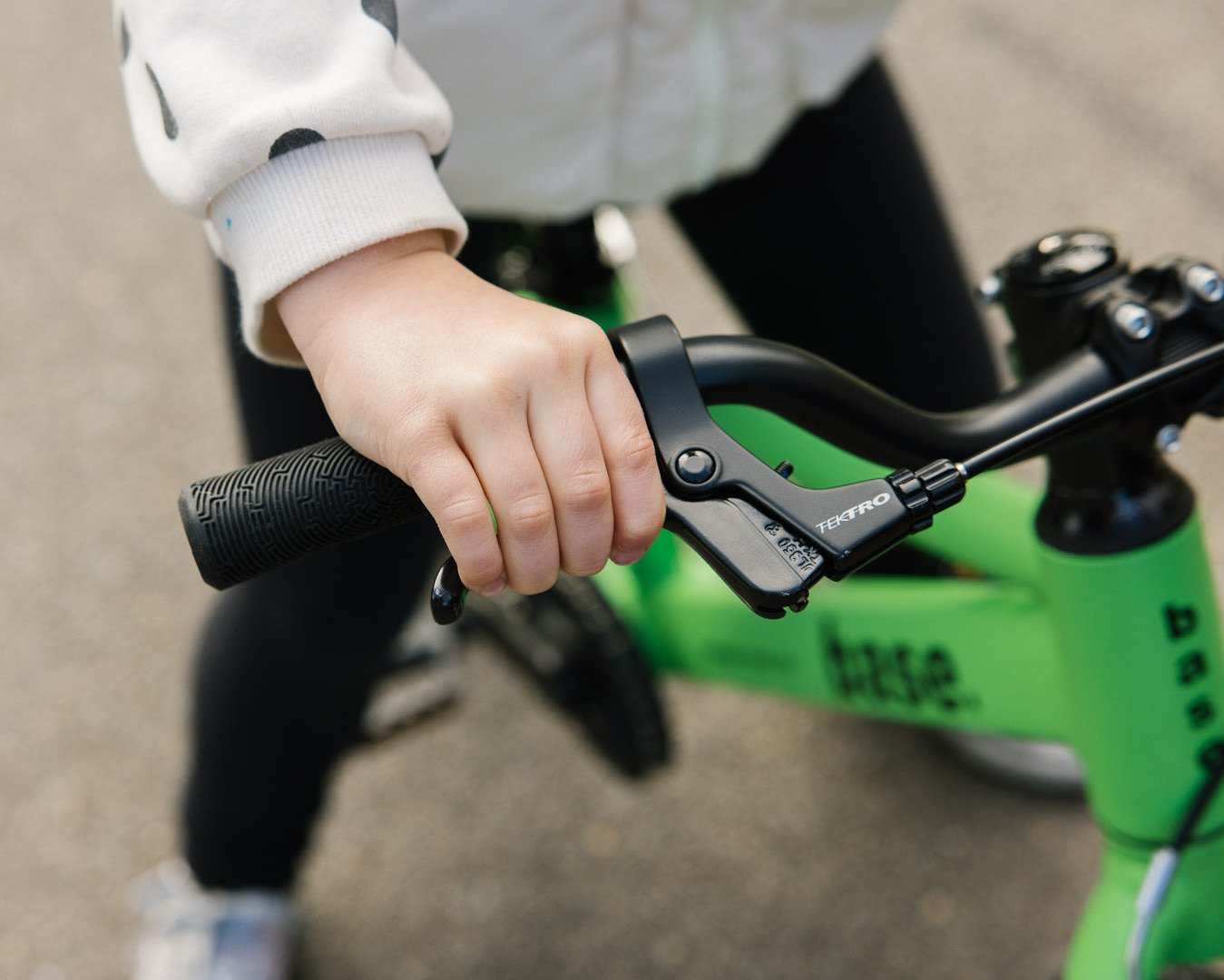Close up of kids hand easily reaching the brake lever on the base 16