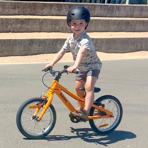 5 year old cleverly standing up and balancing on a 16 inch bike