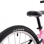 Close-up of a bicycle wheel with Kenda tire on a white background