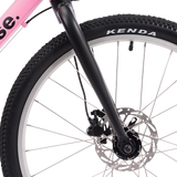 Close-up of a pink bicycle wheel with 'base' branding and Kenda tire.