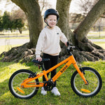 5 year old boy smiling, standing next to his first bike