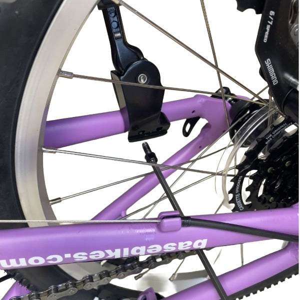 Close-up of a lilac bicycle frame showing parts including Shimano rear derailleur and a lilac frame with 'basebikes.com.au' printed on it.