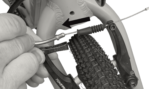 Close-up of a bicycle brake cable being adjusted with a hand holding the brake lever.