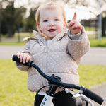 Smiling toddler on a white balance bike