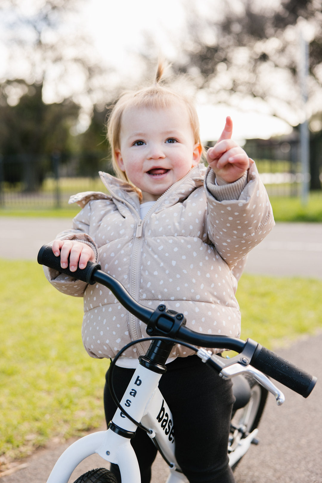 Smiling toddler on a white balance bike