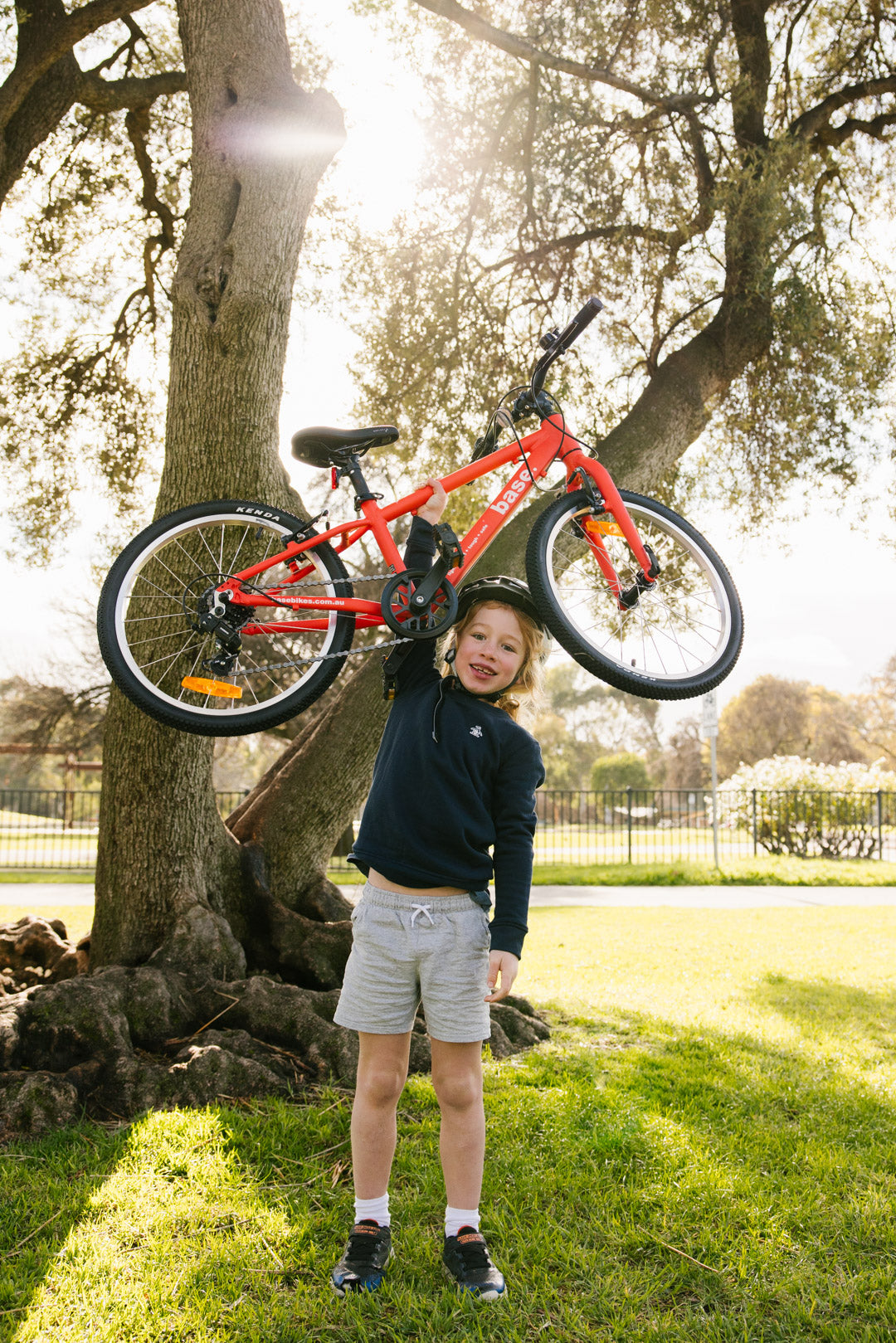 Happy kid holding up his lightweight kids bike