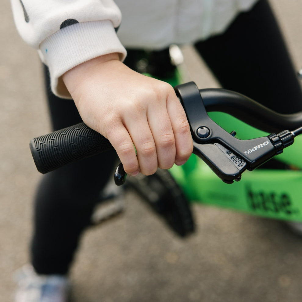 Close up of young girl squeezing the brake lever on her kids bike