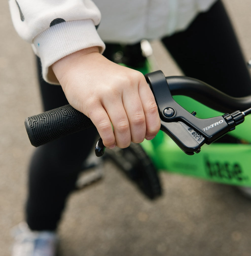 Close up of young girl squeezing the brake lever on her kids bike