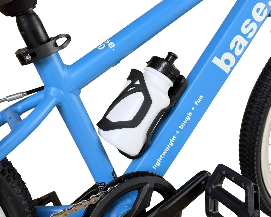 Close-up of a blue bicycle frame with a white and black base water bottle mounted on the down tube, alongside black pedals and chainring.