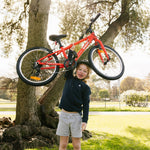 Young boy lifting a lightweight 20 inch bike above his head